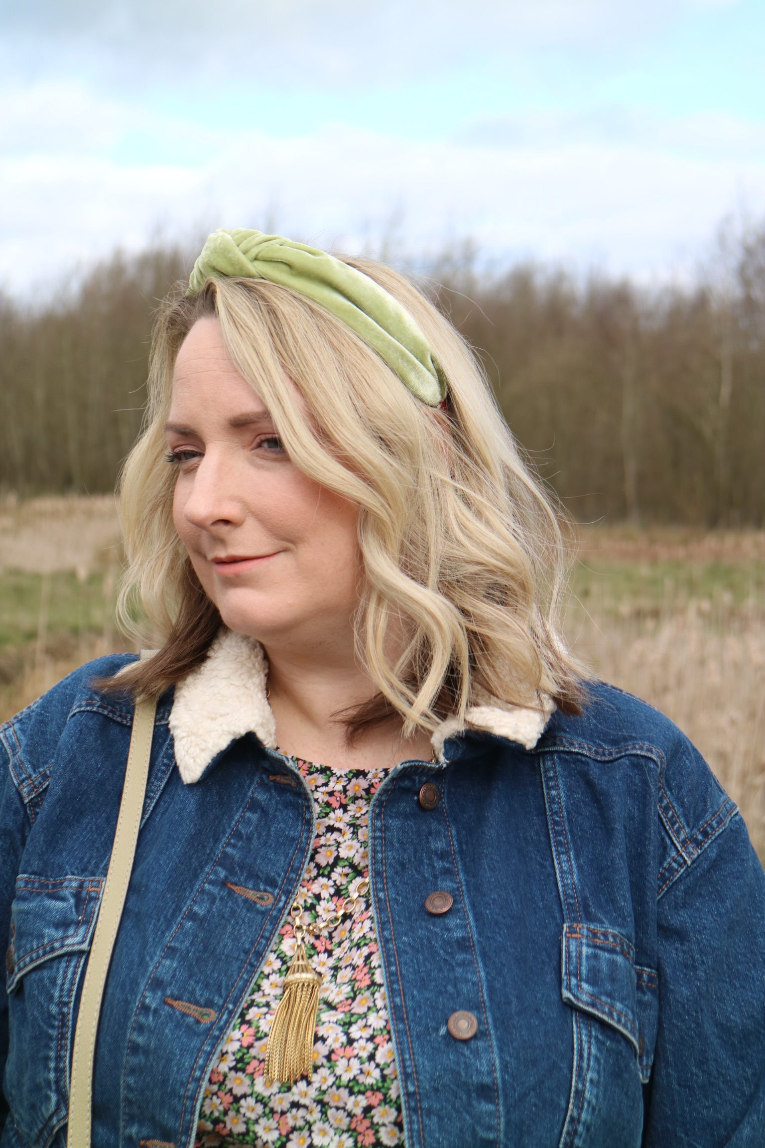 lucy in a field in a floral dress and headband