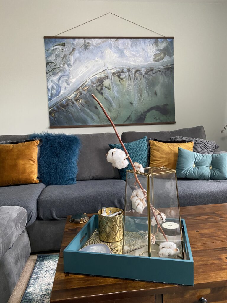 decor on top of a coffee table and the sofa and art in the background