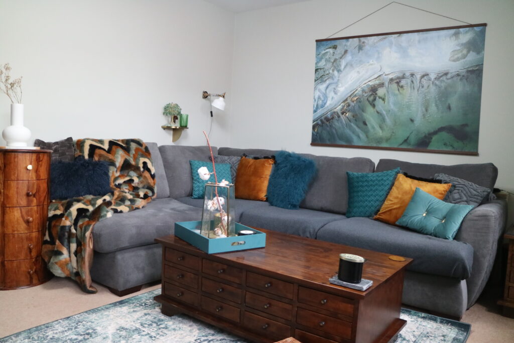 sofa with cushions , wall art behind and throw on