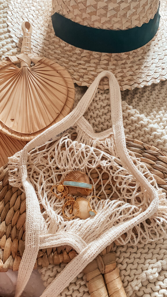 the MV jewellery in a net bag with various neutral things around it 