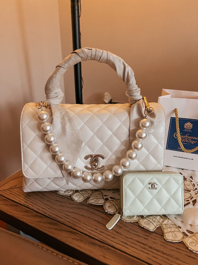 Close up of Lucy’s white Chanel coco handle bag and pistachio Chanel zip purse