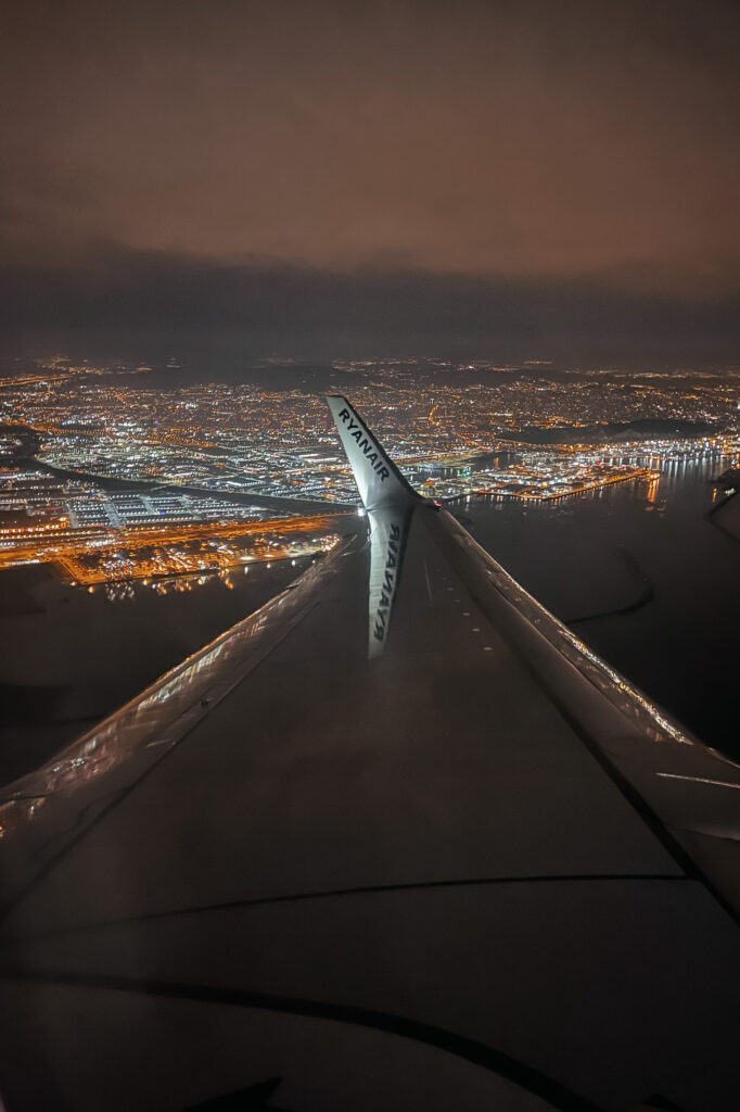 View of Barcelona at night with the plane wing in shot