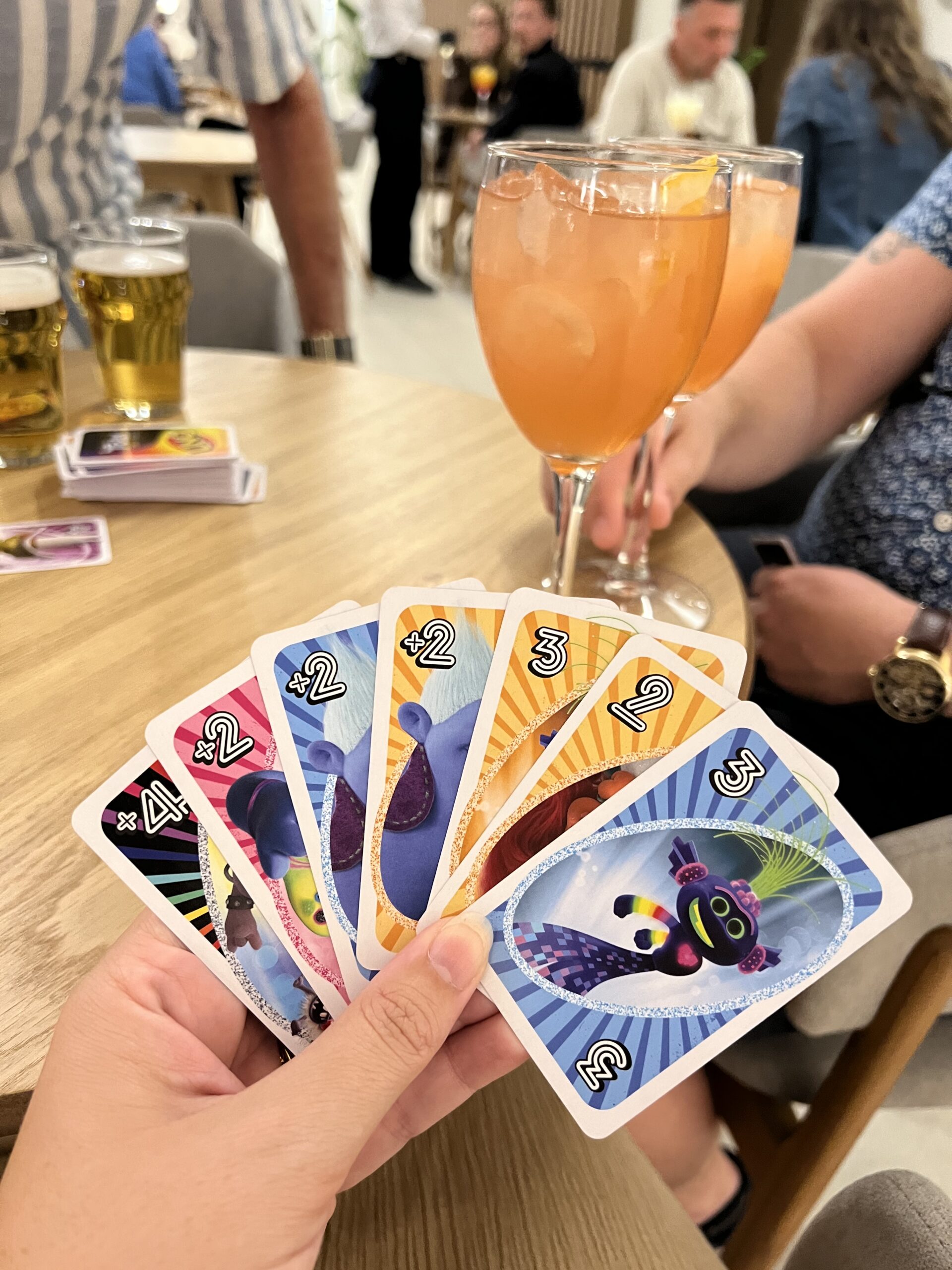 My uno hand (trolls uno!) with cocktails and beer from the bar