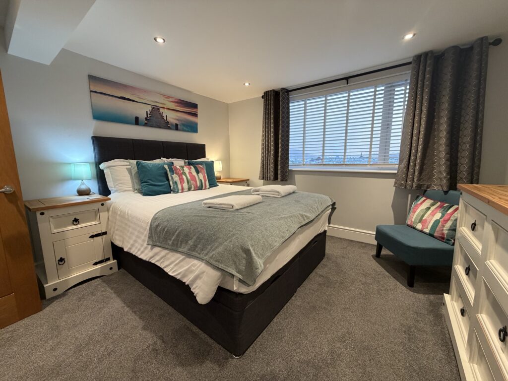 the kingsize bedroom with a window at the side 