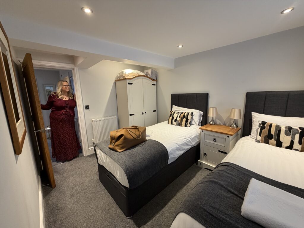lucy stands in the doorway of the twin bedroom