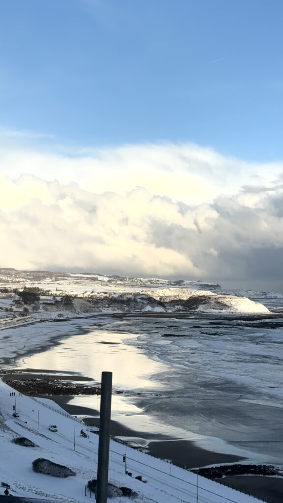 a view from the apartment across the north bay and its covered in snow and blue skies and white clouds