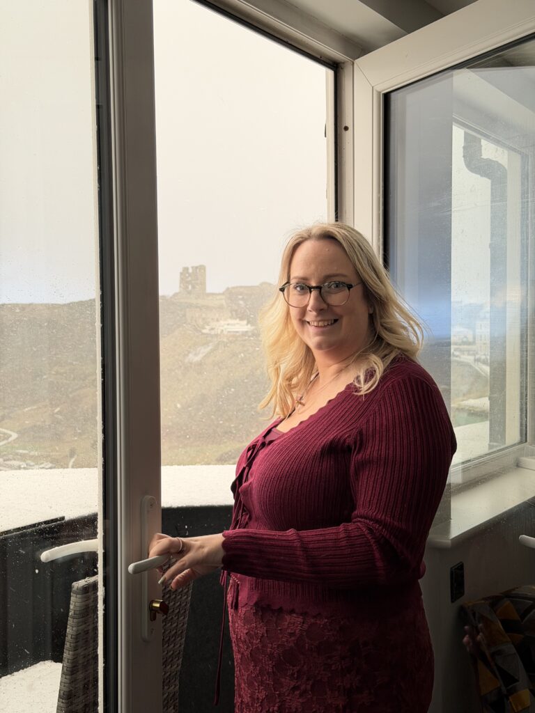 lucy stood at the balcony doors with the snowy view behind her